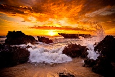 Sunset with waves crashing over rocks